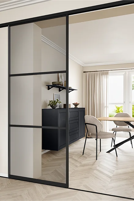 Porte coulissante en applique avec verre gris - solution d'espace moderne avec cadre noir, vue sur la salle à manger ouverte.