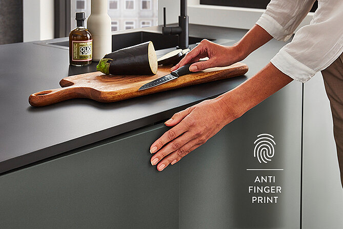 Moderne Küchenarbeitsplatte mit Anti-Fingerabdruck-Technologie, auf der eine Hand ruht, die das saubere und schmutzabweisende Material veranschaulicht.