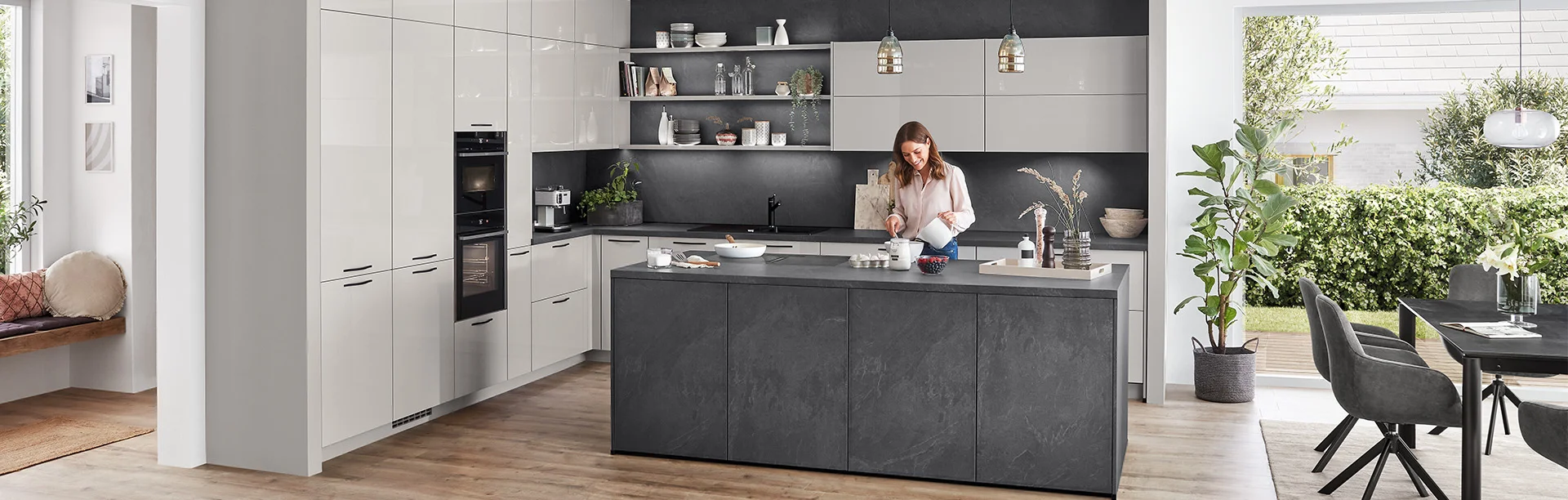 Cette cuisine combine la façade Novalux 519 en gris soie brillant avec un îlot et un panneau arrière foncés en pierre. Le résultat est un look élégant et moderne avec un contraste captivant : le gris soie brillant apporte de la légèreté et reflète la lumière, tandis que les surfaces en pierre foncée donnent de la profondeur et du caractère. Idéal pour tous ceux qui recherchent une solution de cuisine lumineuse mais néanmoins expressive.