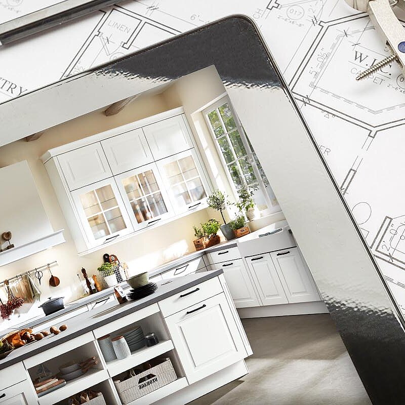 Übergang von den Bauplänen zu einer stilvollen, modernen Küche mit weißen Schränken, die die Transformation vom Design bis zur Fertigstellung bei der Renovierung eines Hauses zeigt.