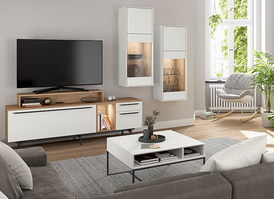 Moderní obývací pokoj s velkou plochou televizí na dřevěném stolku, útulným křeslem a elegantními dekoracemi, které přispívají k stylové atmosféře.