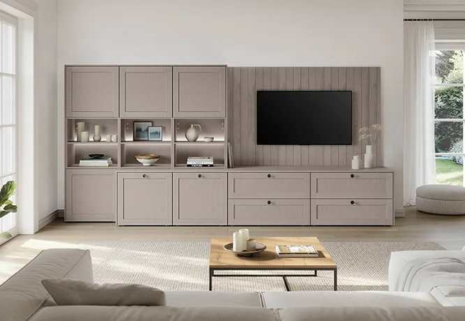 Salón moderno con un sofá de color claro, una elegante mesa de centro y una estantería de pared que combina a la perfección con el televisor.