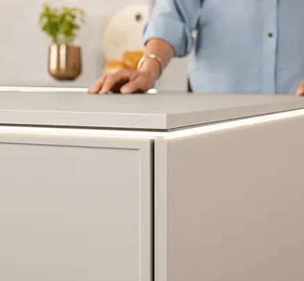 Arbeitsplattenbeleuchtung an einer Küche mit CADRA 746 Front in Sand und beleuchteter Unterschrankkante