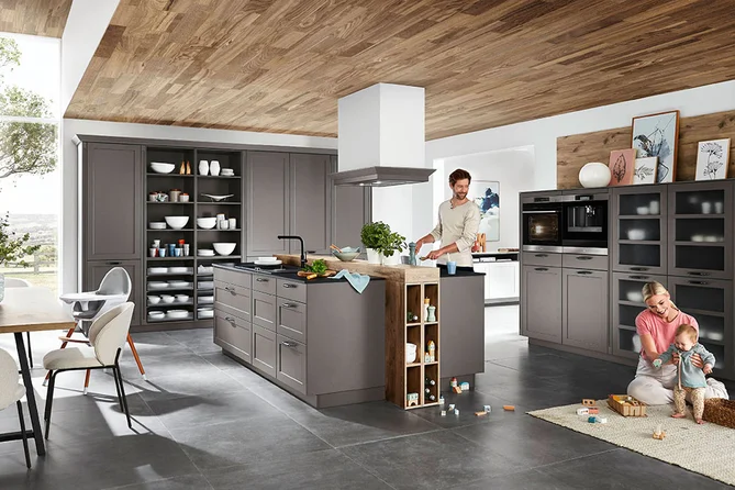 Landhausküche mit großer Insel, Front Nordic in Lack Schiefergrau sowie Pultplatten und offenen Regalen in die Insel integriert. 