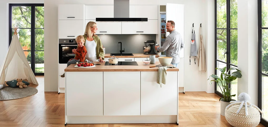 Los frentes de cocina claros y los elegantes electrodomésticos crean un ambiente acogedor.