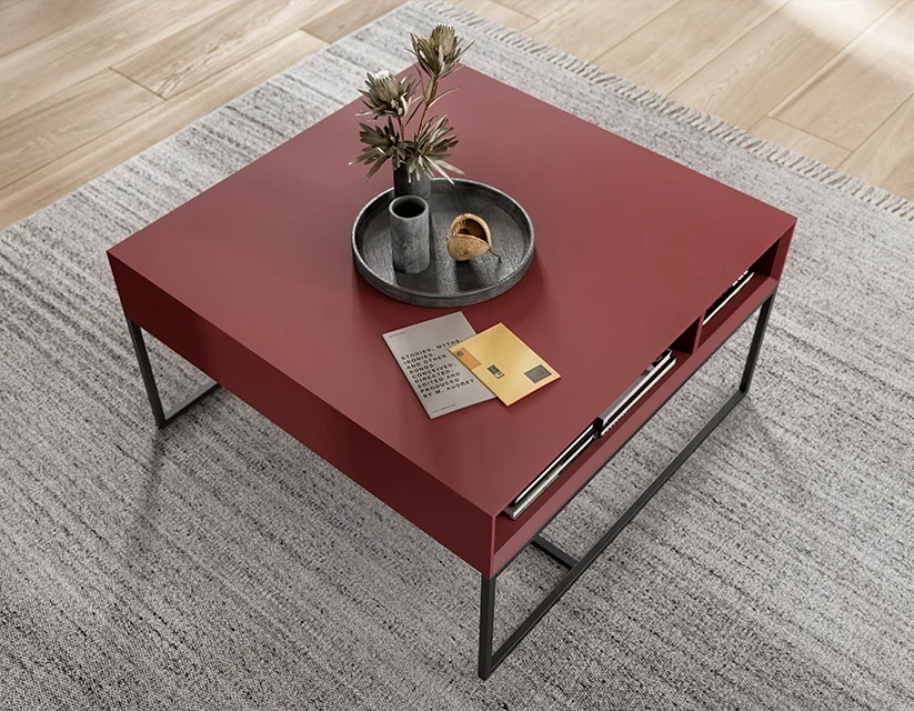 Elegante mesa de café roja moderna con un diseño minimalista, que cuenta con un elegante marco de metal y una bandeja decorativa con una planta, ubicada en un interior acogedor.