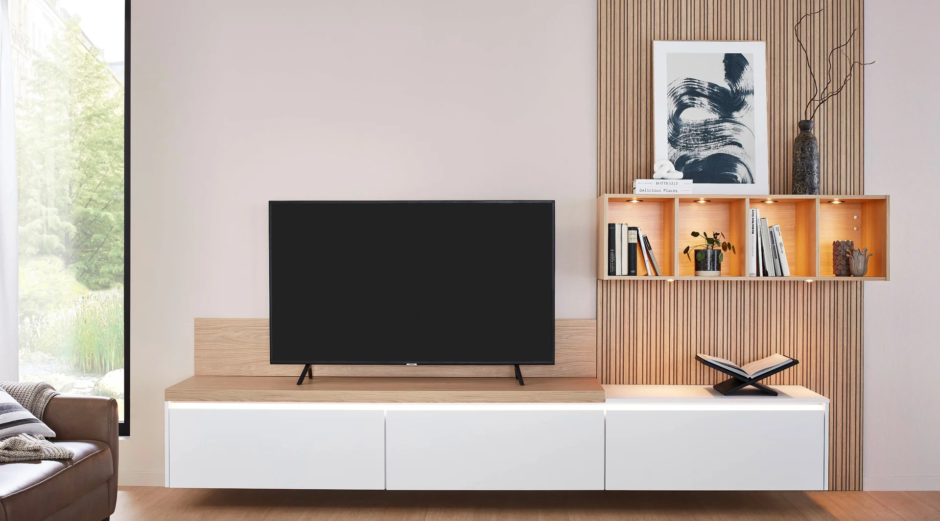 Regalbeleuchtung im Wohnzimmer mit Holzpaneel-Rückwand, offenem Wandregal und TV-Möbel in Holzoptik.
