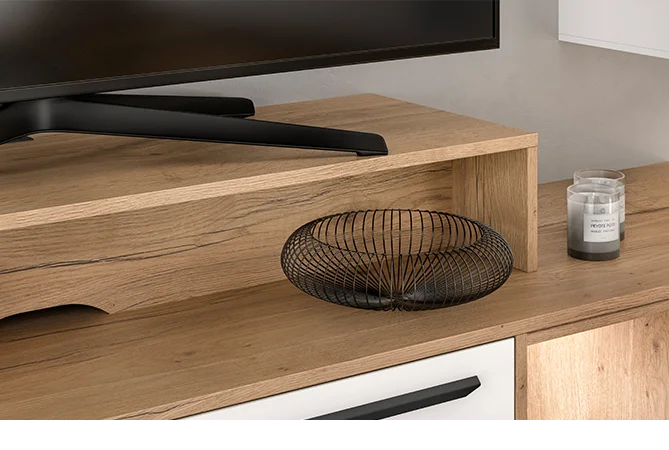 Zeitgenössischer Holzschreibtisch mit einem schlanken schwarzen Monitor, einer minimalistischen Metall-Fruchtschale und einer kleinen duftenden Kerze, die ein modernes und sauberes Arbeitsumfeld schafft.