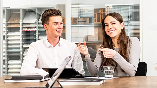 Zwei Auszubildende im Bereich E-Commerce tauschen sich in einem Besprechungsraum über digitale Strategien aus – praxisnahe kaufmännische Ausbildung mit Fokus auf Onlinehandel.