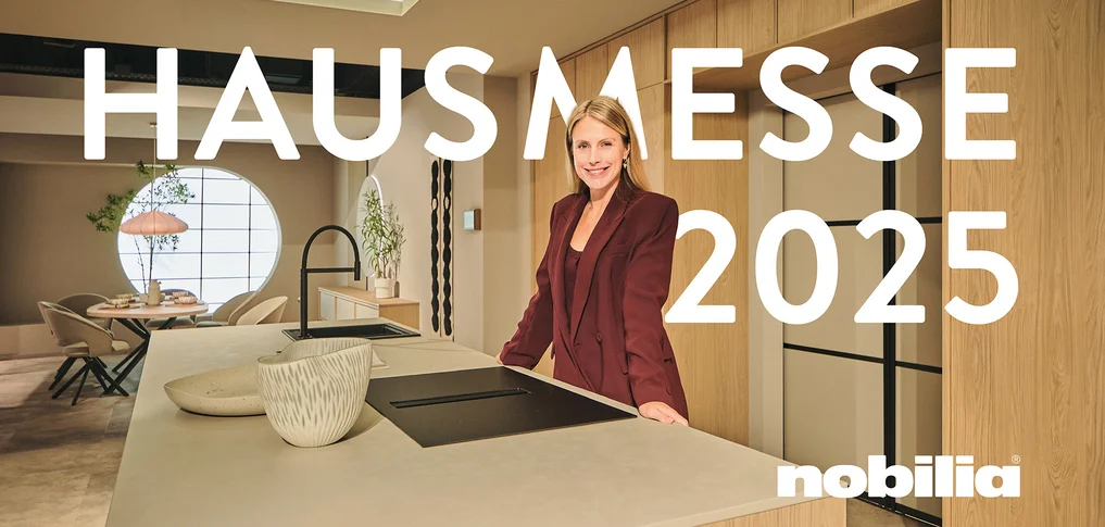 Blonde Frau steht in einer offenen Küche aus der Designlinie Sakura