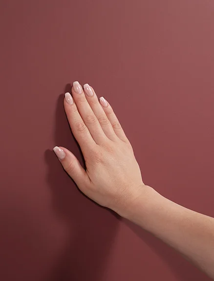 Dłoń dotyka frontu w kolorze rdzawoczerwonym ultra matowym z programu EASYTOUCH 963 o właściwościach zapobiegających pozostawianiu odcisków palców.