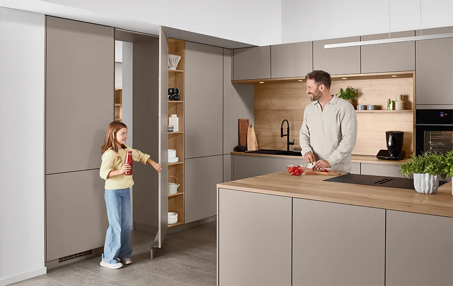 Moderne Familienküche in warmen Macchiato Farben mit Holzdetails und praktischem Stauraum für einen wohnlichen Alltag.