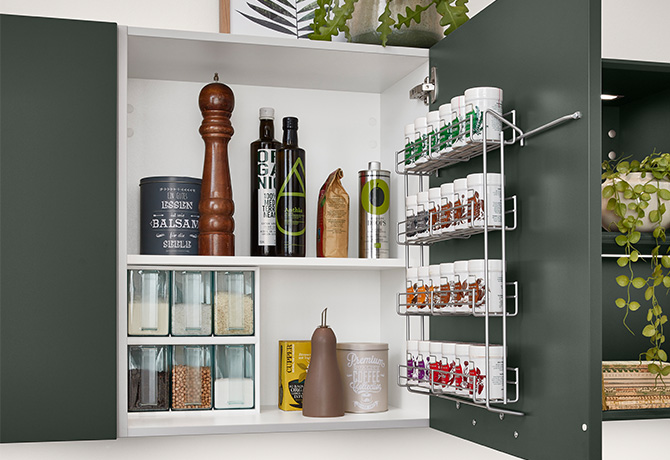 Modern kitchen cabinet with neatly organized spices, condiments, and jars on shelves, featuring a convenient pull-out corner storage solution.