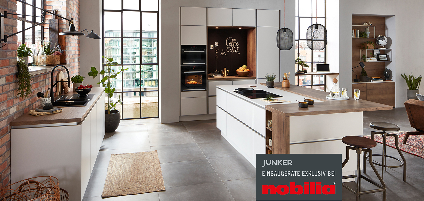 Großzügige, offene Küche mit angrenzendem Wohnbereich, Front Fashion 171 in Seidengrau, mit integrierten Junker Einbaugeräten exklusiv bei nobilia.