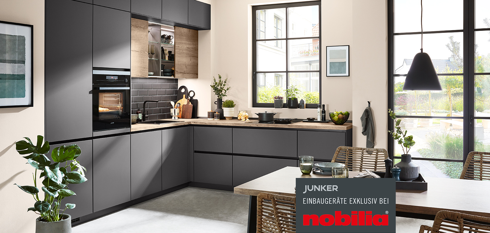 Moderne Küchengestaltung mit eleganten dunklen Schränken, Edelstahlgeräten und einer eleganten Frühstücksbar, die Funktionalität mit zeitgemäßer Ästhetik verbindet.