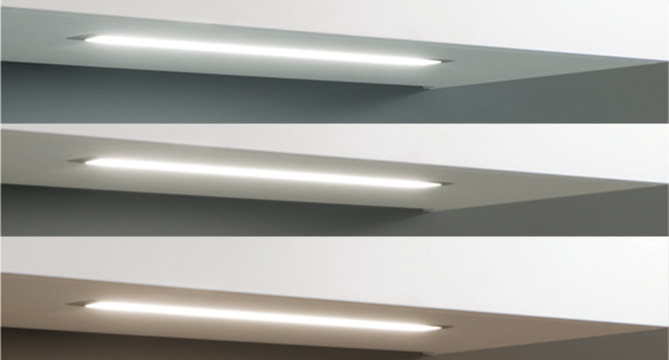 Trois luminaires modernes et élégants installés sous des étagères, émettant une lumière douce et diffuse idéale pour les designs intérieurs contemporains.