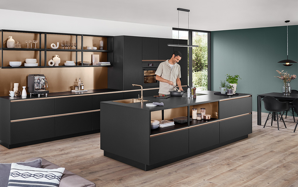 Moderne Küche mit Fronten in Schwarz Premium matt aus dem Programm SENSO 496 und goldfarbenen Akzenten im offenen Regalbereich.