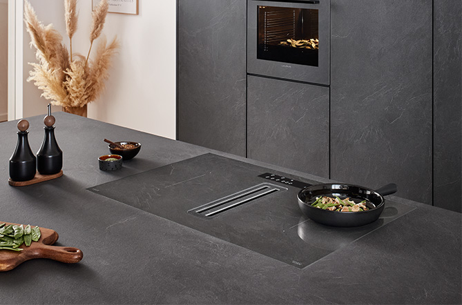 nobilia Xtra Hob Kochfeld mit integriertem Dunstabzug in Grauschiefer Nachbildung 303 – flächenbündig in Arbeitsplatte und Küchenfront Stoneart 303 integriert – einheitliches Design mit unsichtbarer Technik – modernes Küchenambiente mit passendem Backofen in gleicher Farbe