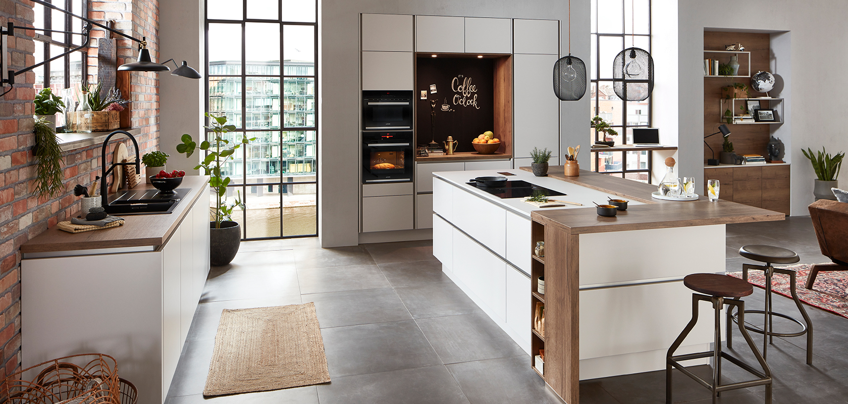 Contemporary kitchen with brick walls, white cabinets, central island, stainless appliances, and natural light, creating a cozy, stylish space.