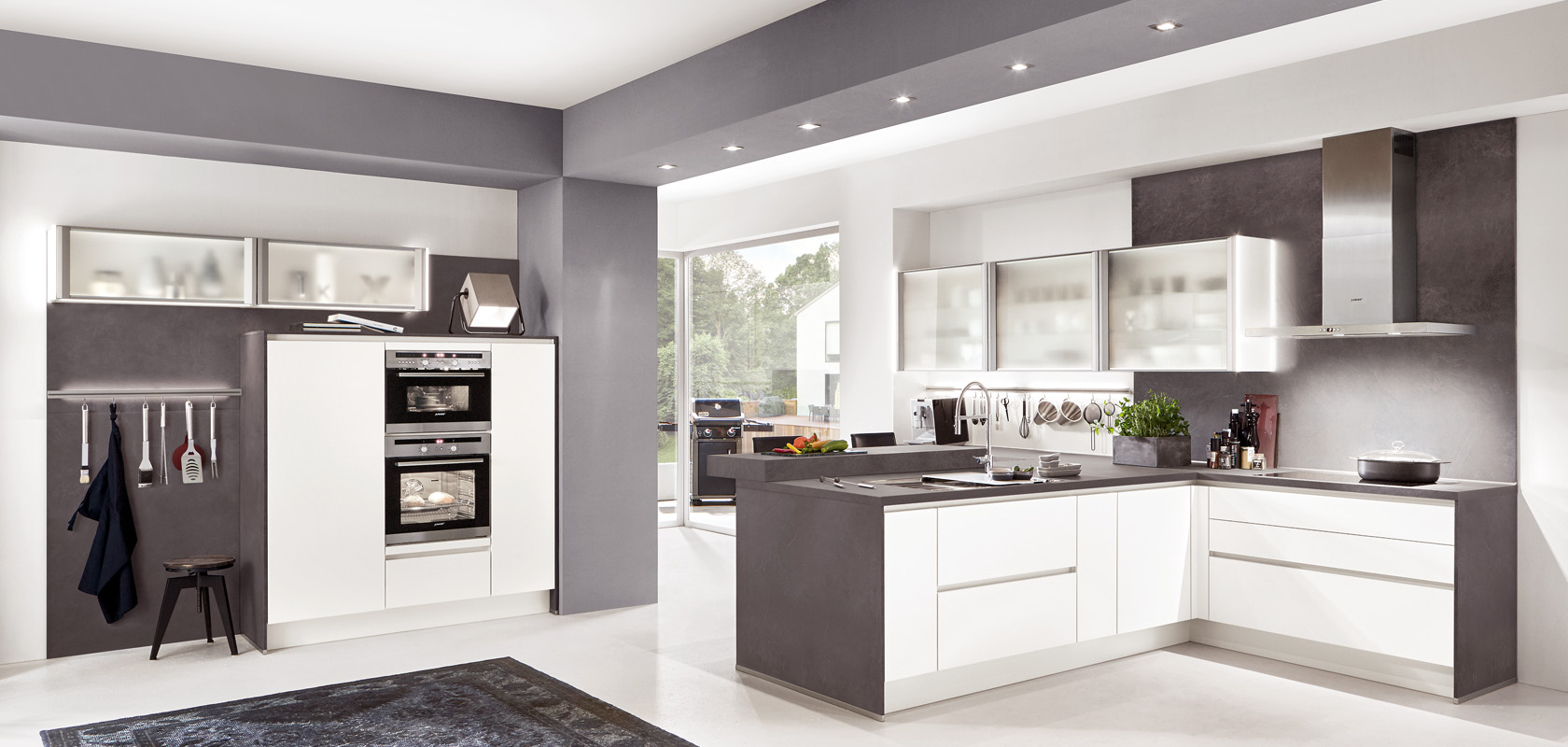 Moderní kuchyň s lesklými skříňkami, nerezovými spotřebiči a elegantním designem kombinujícím bílé a šedé tóny, nabízející moderní vzhled.