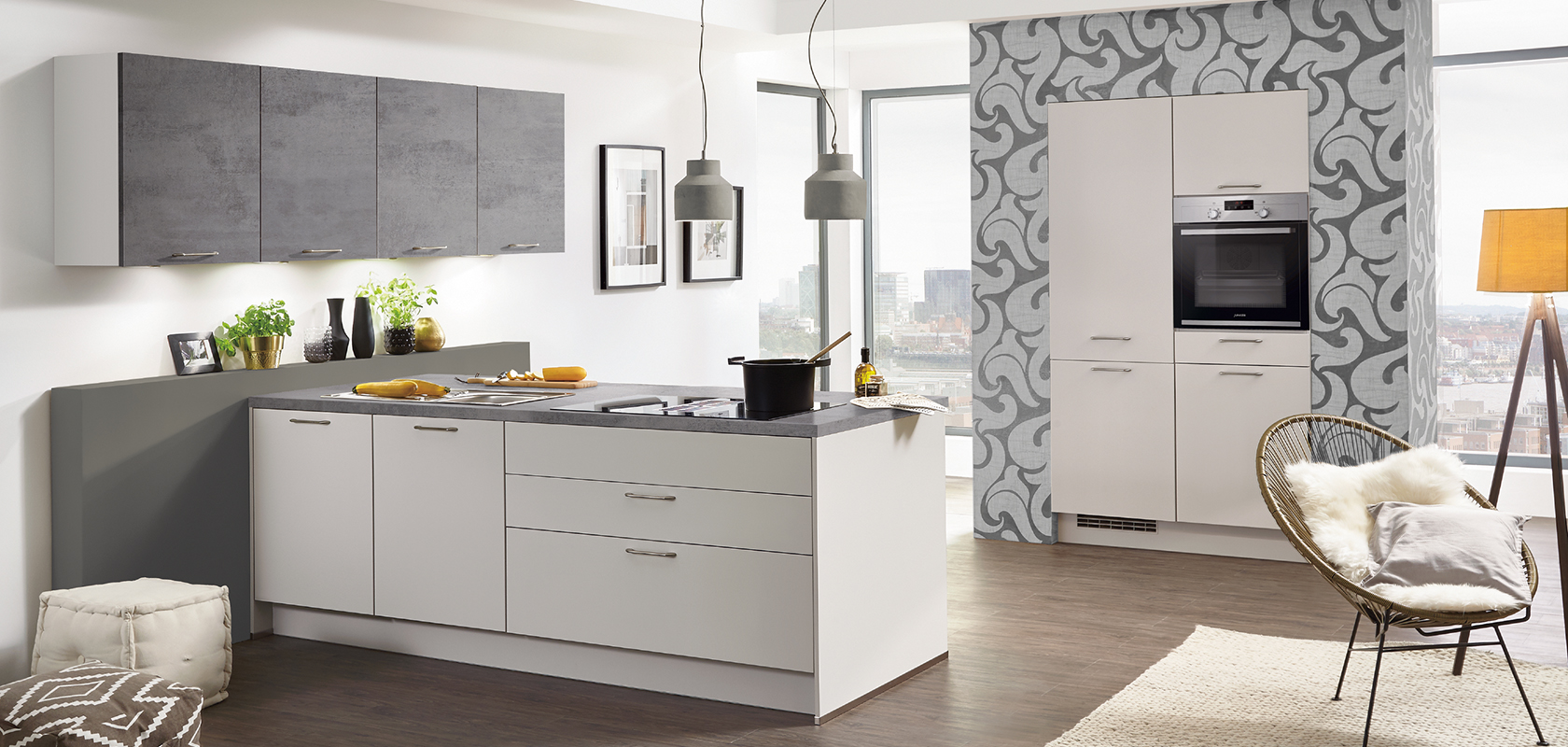 Interior de cocina moderna con gabinetes blancos limpios, electrodomésticos de acero inoxidable y una acogedora área de asientos iluminada por luz natural de grandes ventanas.