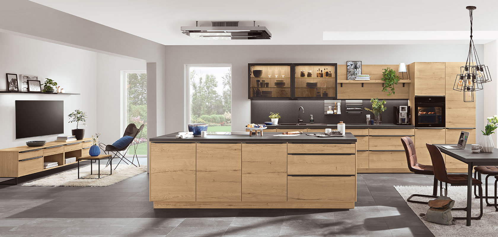 Espaciosa cocina moderna con elegantes gabinetes de madera, electrodomésticos de acero inoxidable y una gran isla, que se integra perfectamente a una acogedora área de estar con luz natural.