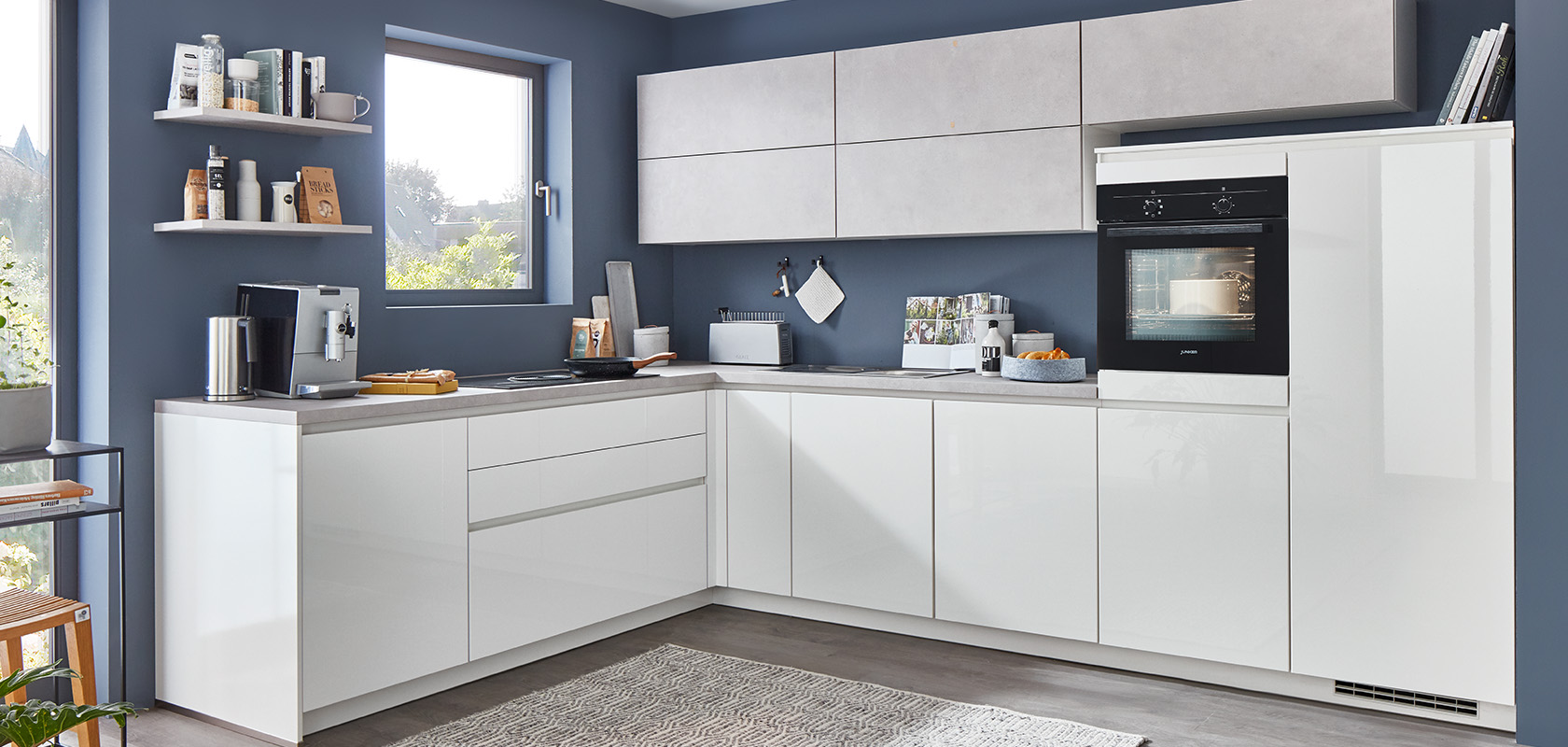 Moderne keuken met witte kasten, strakke apparaten en grijze accenten. Een netjes georganiseerde ruimte met een minimalistische esthetiek en een comfortabele, uitnodigende sfeer.