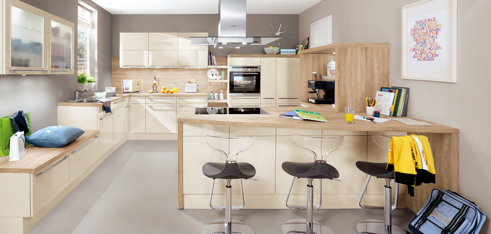 Interni di cucina moderna che mostrano un design elegante con armadi in legno, un'isola centrale, elettrodomestici in acciaio inossidabile e un'area salotto accogliente con sgabelli eleganti.