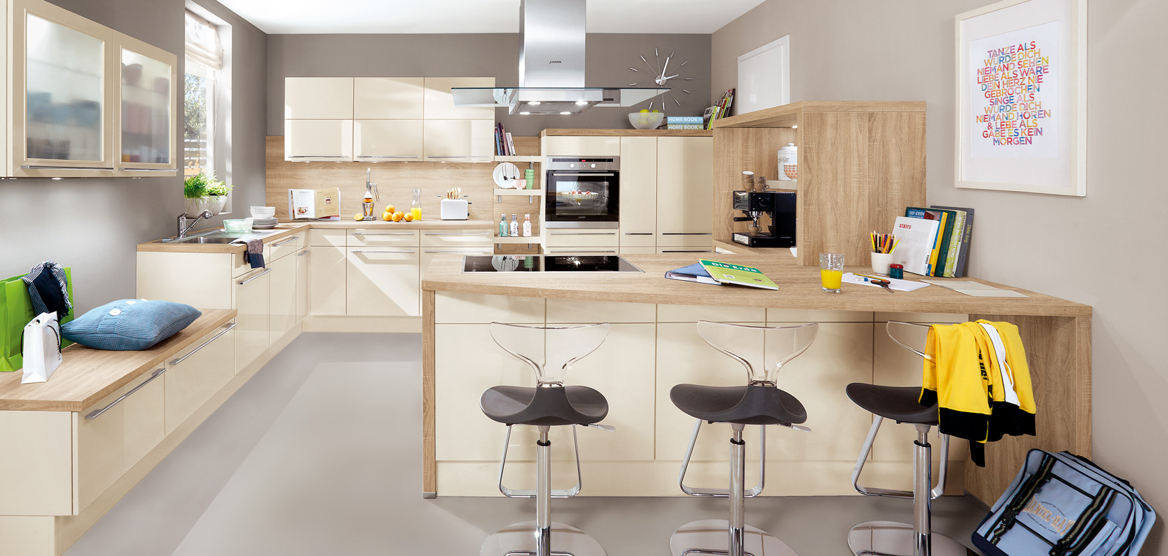 Modern kitchen interior showcasing a sleek design with wooden cabinets, a central island, stainless steel appliances, and a cozy seating area with stylish stools.