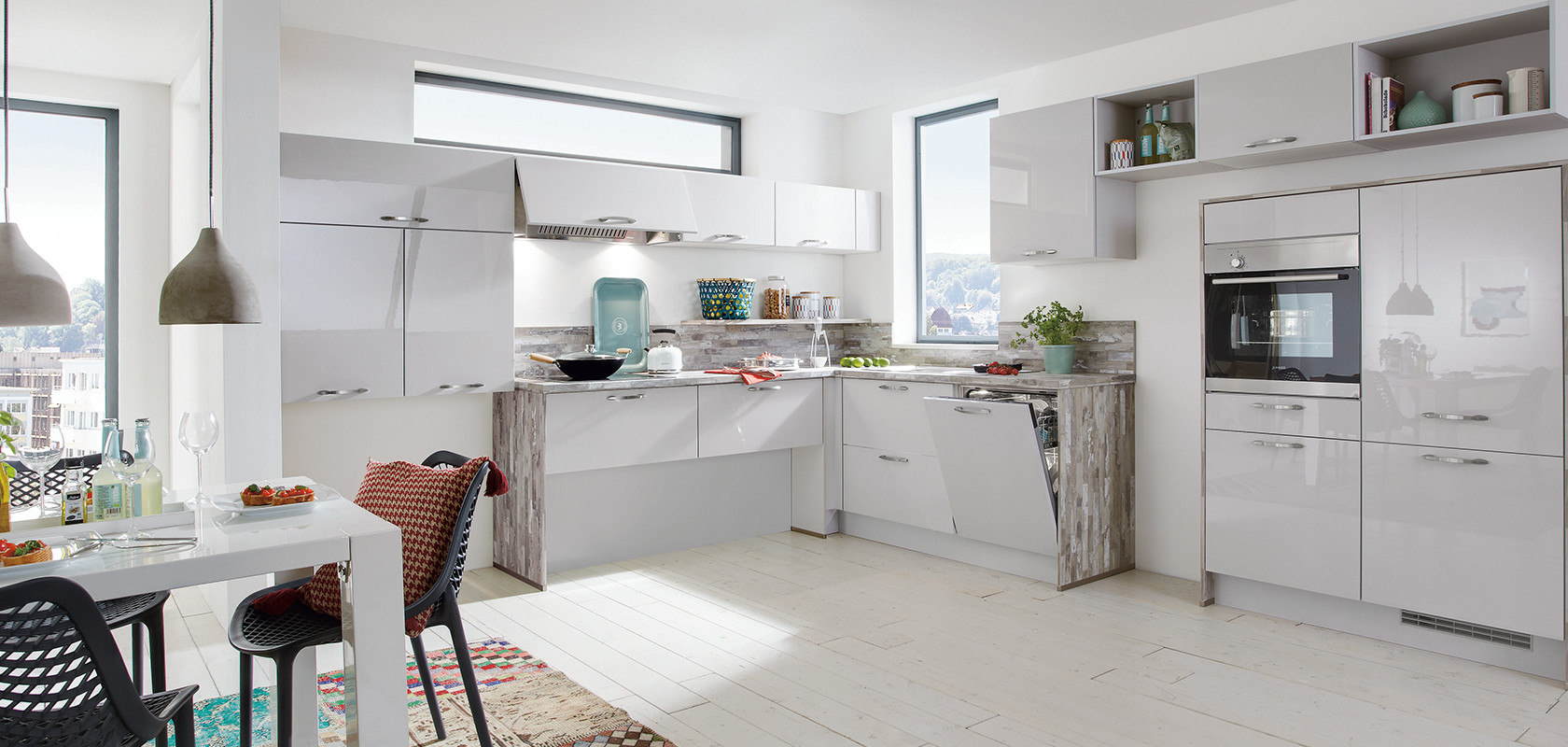 Bright modern kitchen with white cabinetry, stainless steel appliances, and pops of color from decorative items and a multicolored area rug.