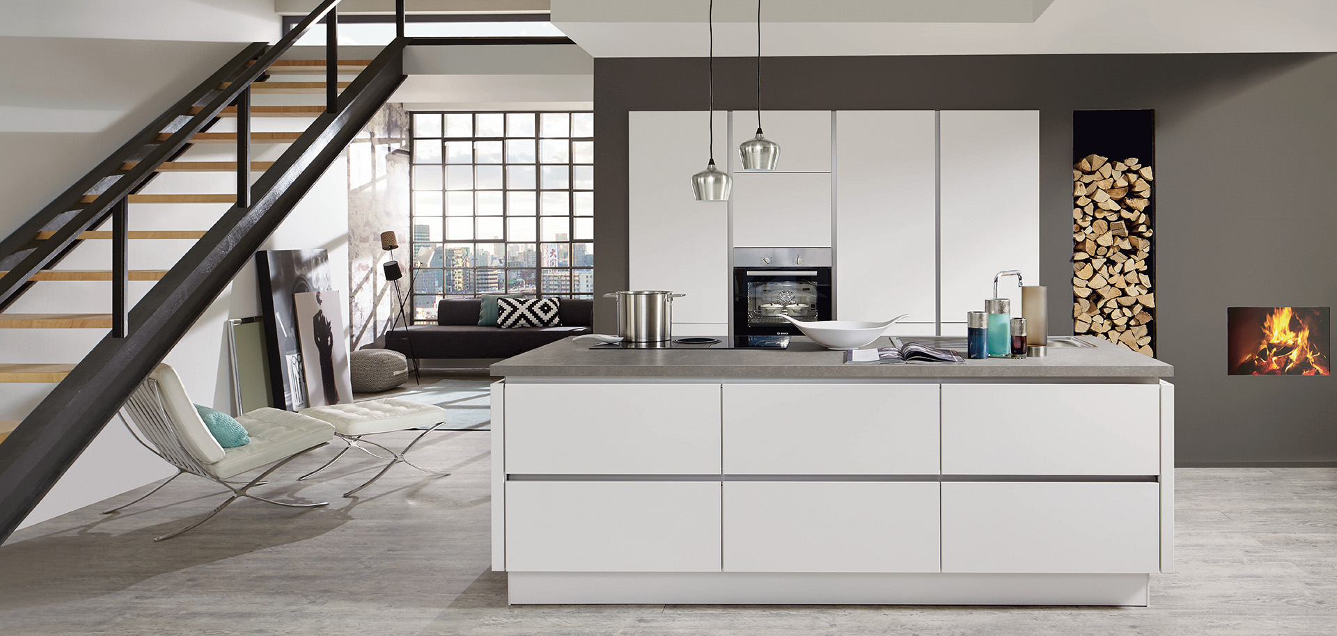 Modern kitchen interior with clean lines featuring white cabinetry, stainless steel appliances, and an adjacent cozy living area with a fireplace.