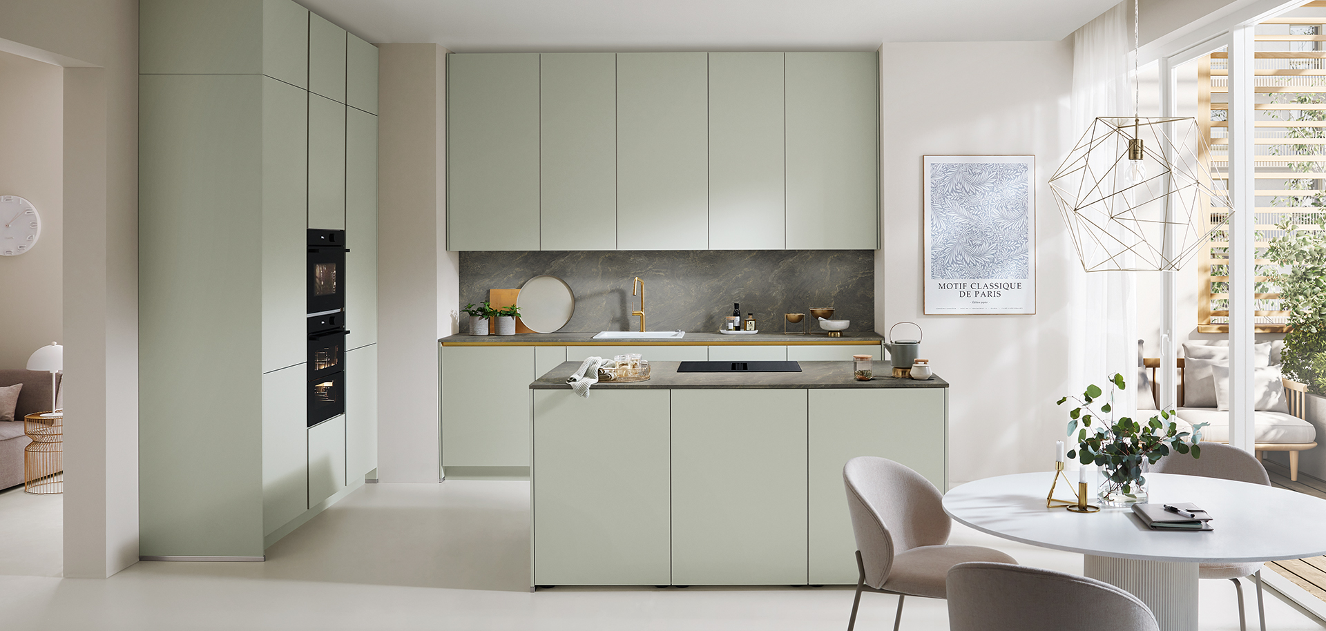 Cucina moderna con mobili verde pastello, elettrodomestici integrati e un'accogliente area pranzo che presenta un design minimalista e un'atmosfera luminosa e ariosa.