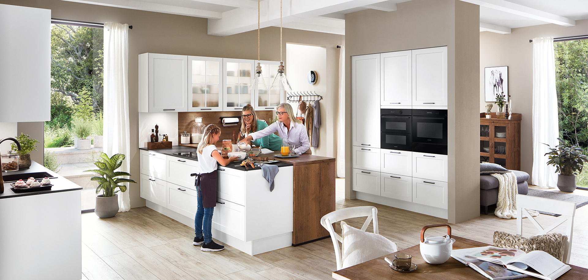 A modern kitchen filled with natural light where a family enjoys time together, showcasing sleek white cabinetry and stainless steel appliances.