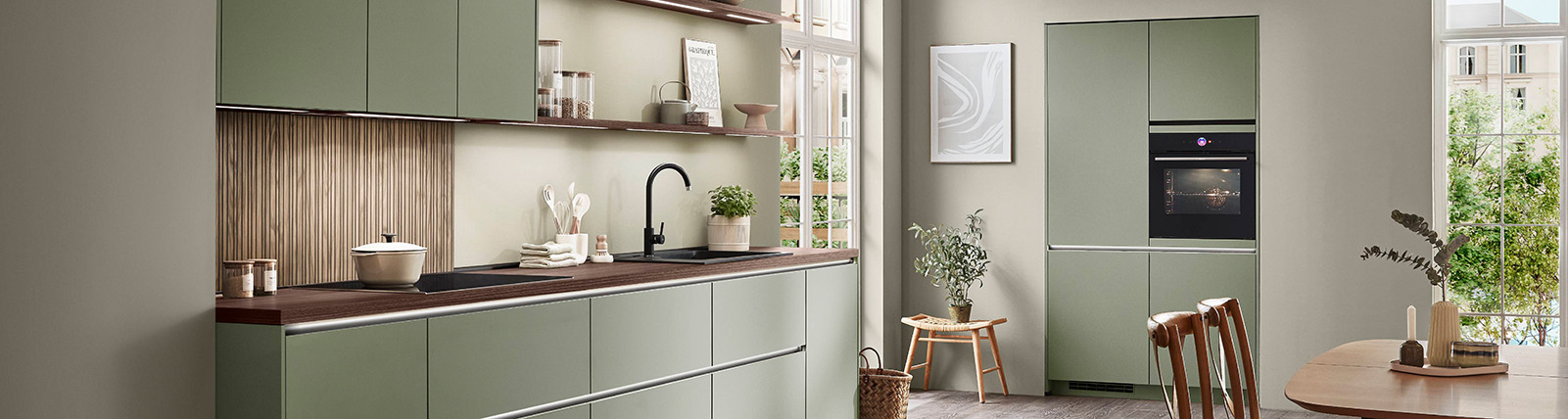 Intérieur de cuisine moderne avec des armoires blanches propres, des appareils haut de gamme et une femme détendue profitant d'une boisson dans un fauteuil confortable et élégant.