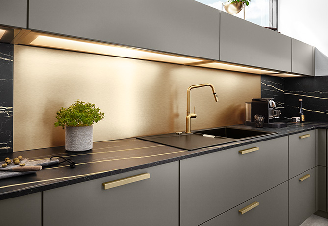 Bild einer Küche mit dem Fokus auf die goldfarbene Küchenrückwand.