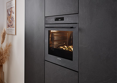 Backofen im gleichen Farbton wie die Küchenfront Stoneart 303. Moderne Einbauküche im dunklen Steinlook mit abgestimmtem Gerät für ein einheitliches Design.