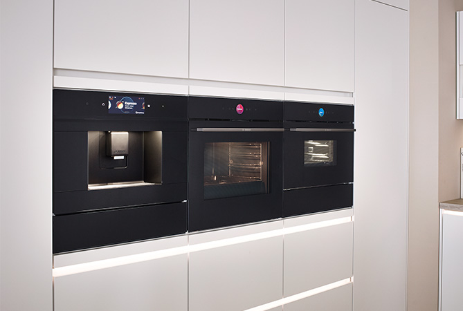 Moderne Kompaktgeräte mit integrierter Kaffeemaschine in einer nobilia Küche mit Front SENSO 490 in Alpinweiß Premium matt. Perfekte Kombination aus Funktion und Design für anspruchsvolle Küchennutzung.