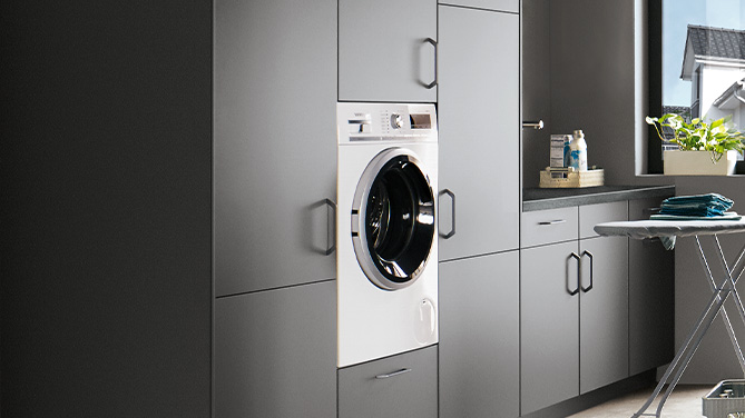 Integrierte Waschmaschine in nobilia Hauswirtschaftsraum mit Front TOUCH 334 in Steingrau supermatt. Perfekt eingebunden in ein funktionales Schranksystem für moderne Haushaltslösungen.