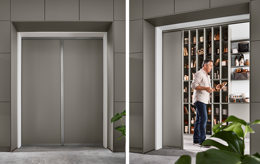 Moderní, na míru vyrobená šatní skříň s elegantními šedými dveřmi je představena ve dvou stavech: zavřená a otevřená, kdy muž vybírá boty z organizovaného interiéru.