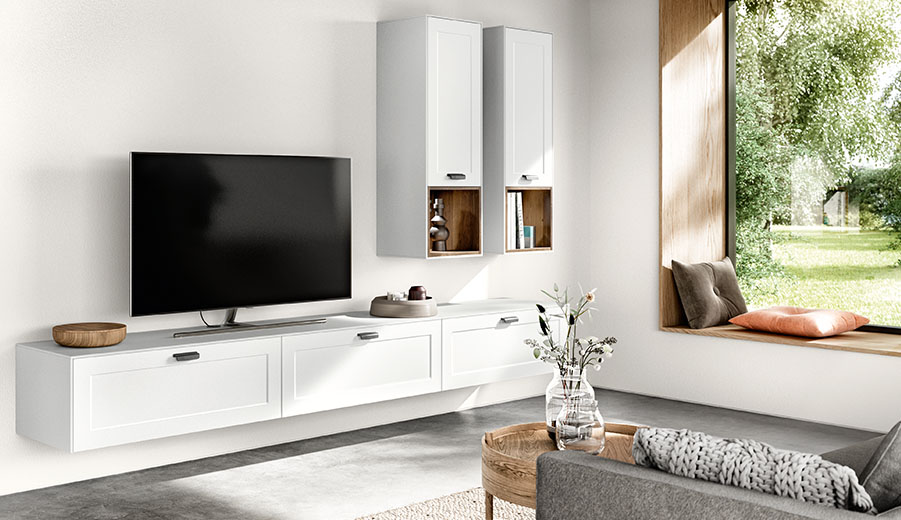 Modernes Wohnzimmerinterieur mit elegantem weißen Unterhaltungseinheit, wandmontierten Schränken und einem großen Fenster mit Blick auf saftiges Grün.