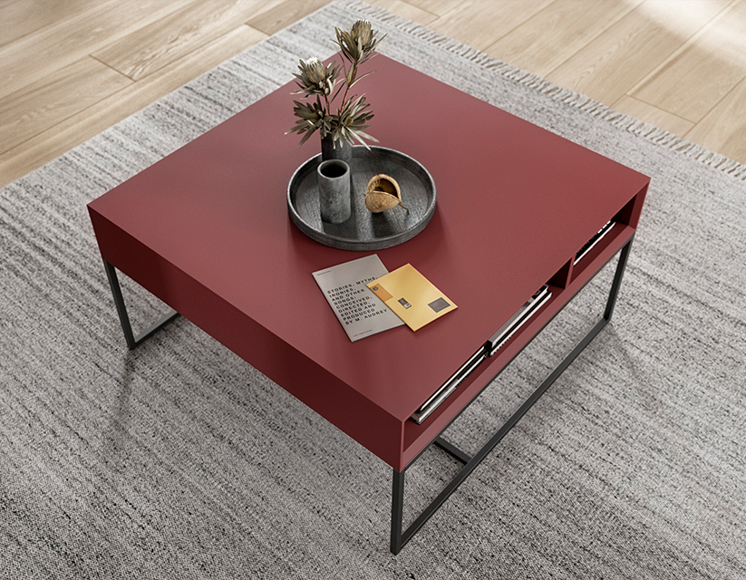 Elegantní moderní červený konferenční stůl s minimalistickým designem, s elegantním kovovým rámem a dekorativní podnos s rostlinou, umístěný v útulném interiéru.