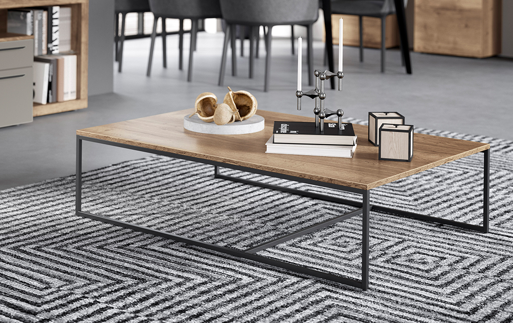 Modern living room showcasing a stylish wooden coffee table with metal legs, set on a geometric patterned rug in a contemporary interior setting.