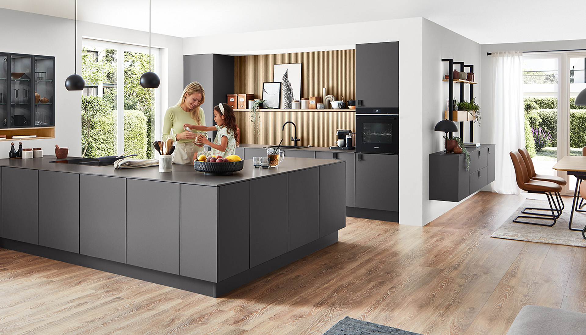 Moderne ruime keuken met een stijlvol ontwerp, voorzien van een centraal eiland, geïntegreerde apparaten en een gezin dat samen geniet van een kookactiviteit.