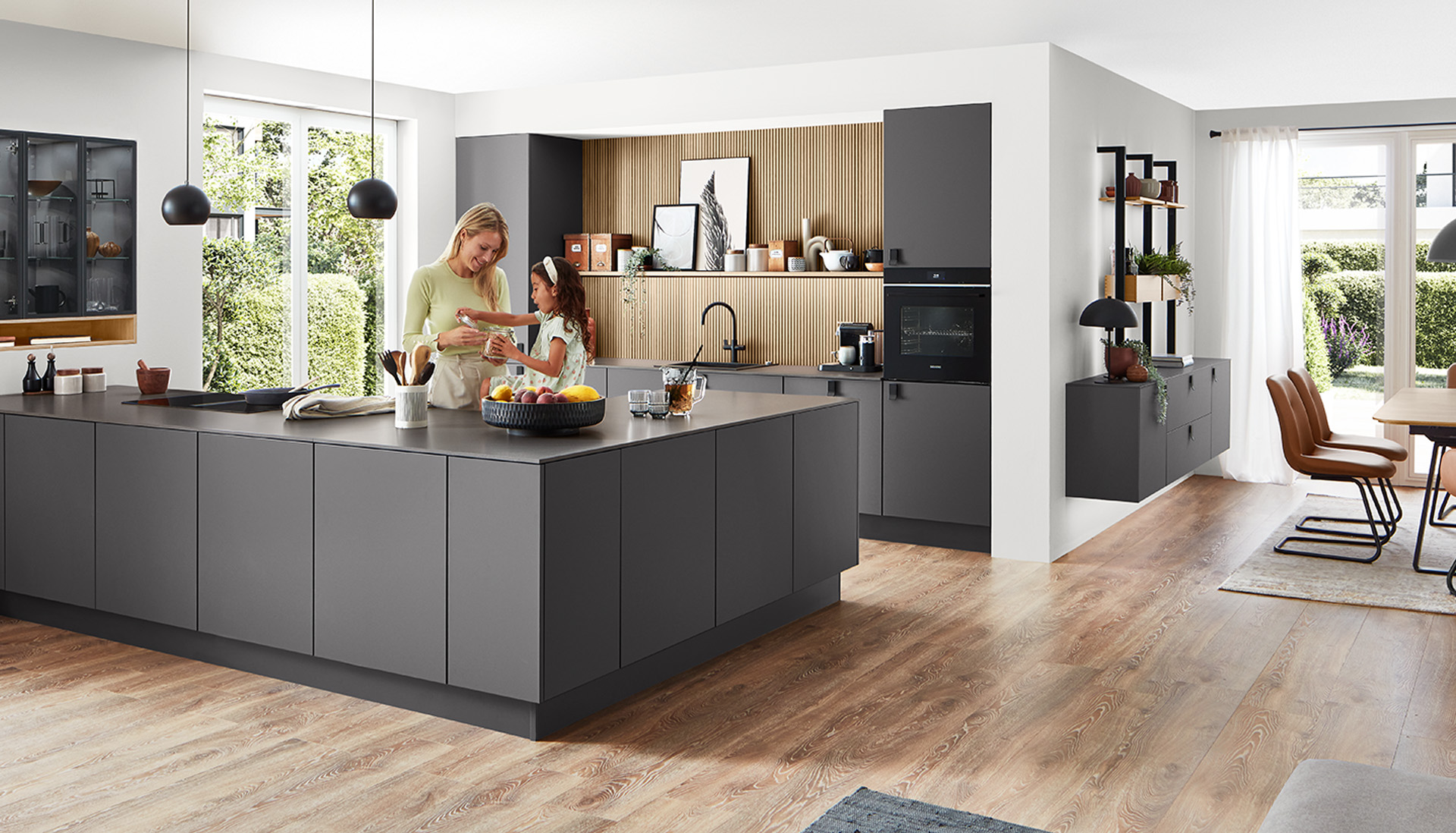 Cucina moderna e spaziosa con un design elegante, dotata di un'isola centrale, elettrodomestici integrati e una famiglia che si diverte a cucinare insieme.