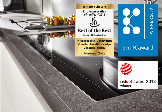 Modern kitchen featuring a sleek undermount sink with awards for innovation and design, including the "KitchenInnovation of 2018" and "Red Dot Award 2018".