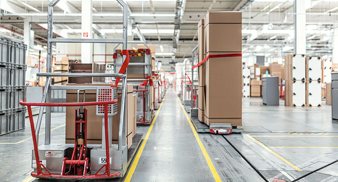 Moderne magazijninterieur met rijen planken met dozen en een transportsysteem met transportbanden voor efficiënte logistiek en pakketverwerking.