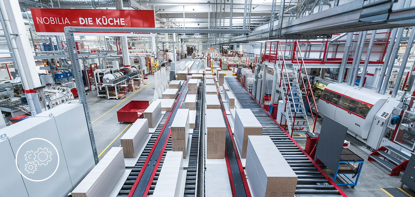 Un amplio y moderno piso de fabricación lleno de maquinaria automatizada y cintas transportadoras que manejan la producción eficiente de bienes en una instalación limpia y bien iluminada.