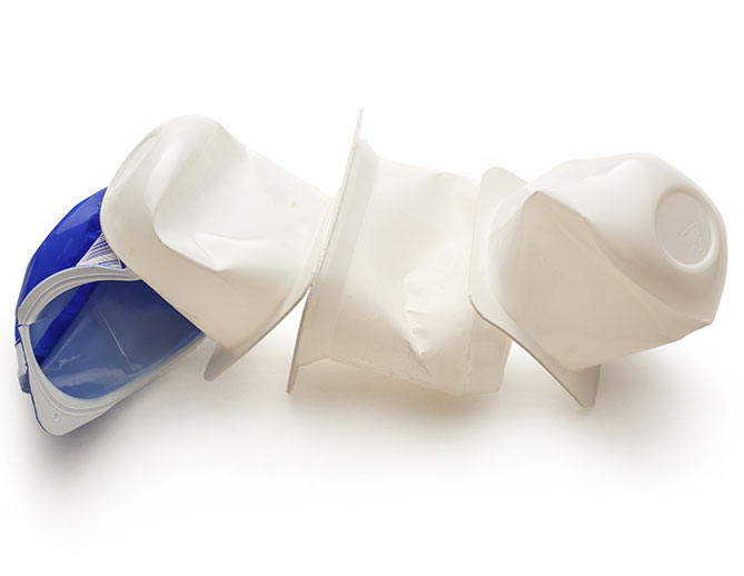 A pair of white, disposable personal protective equipment suits with hoods, alongside a blue hard hat, on a clean white background.